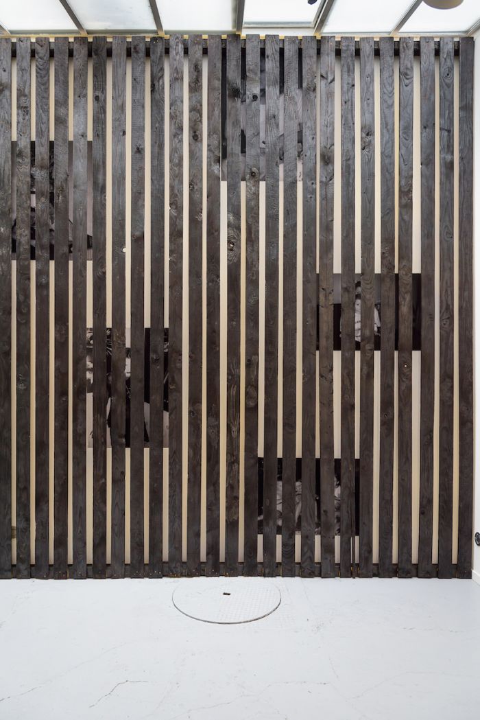 alicia-zaton-za-2014-2015-installation-en-brois-brule-a-la-dimension-du-mur-de-la-galerie-poster-d-archives-personnelles-colle-au-mur-derrieres-des-lattes-de-bois-590x370cm-6155723b72e12142e89b0aba4ce2e471